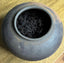 Black ceramic pot with korean yellow tea a wooden surface